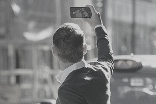 A guy is taking selfie shown from behind