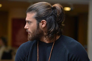 A mascular guy in stylish ponytail hairstyle.
