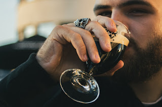 A man drinking wine in a glass.