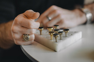 A man's hand, wearing a signet ring.