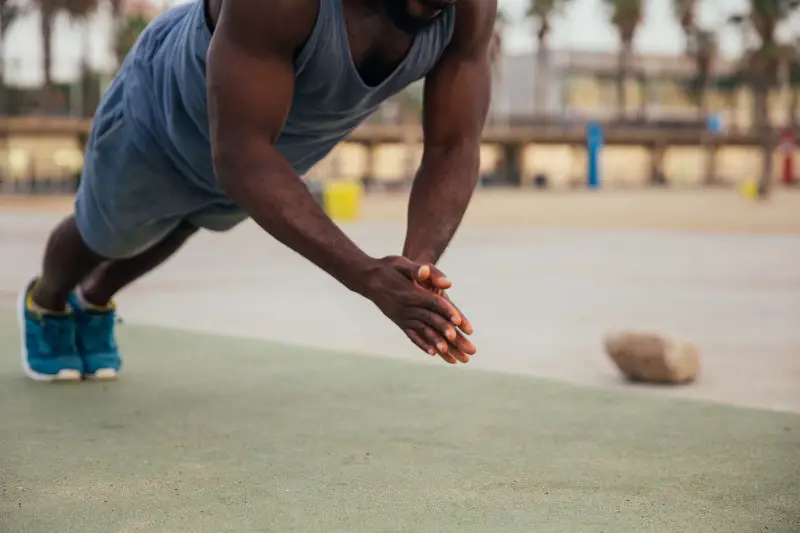 A man, doing clap push_ups.