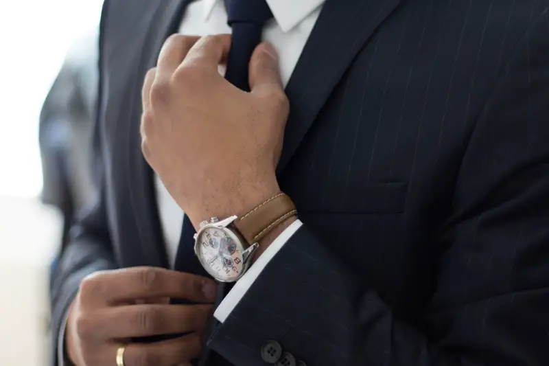 A man adjusting his tie.