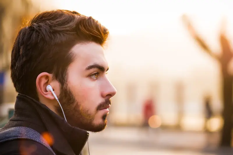 A man plug earphone in his ear.