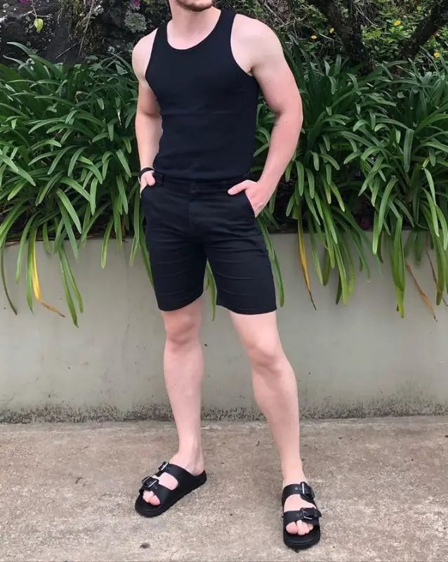 Man wearing black wife beater and black shorts.