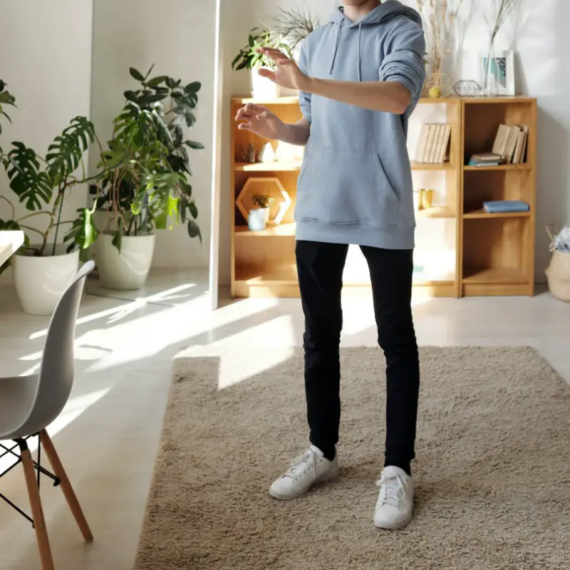 A teen boy standing at home.