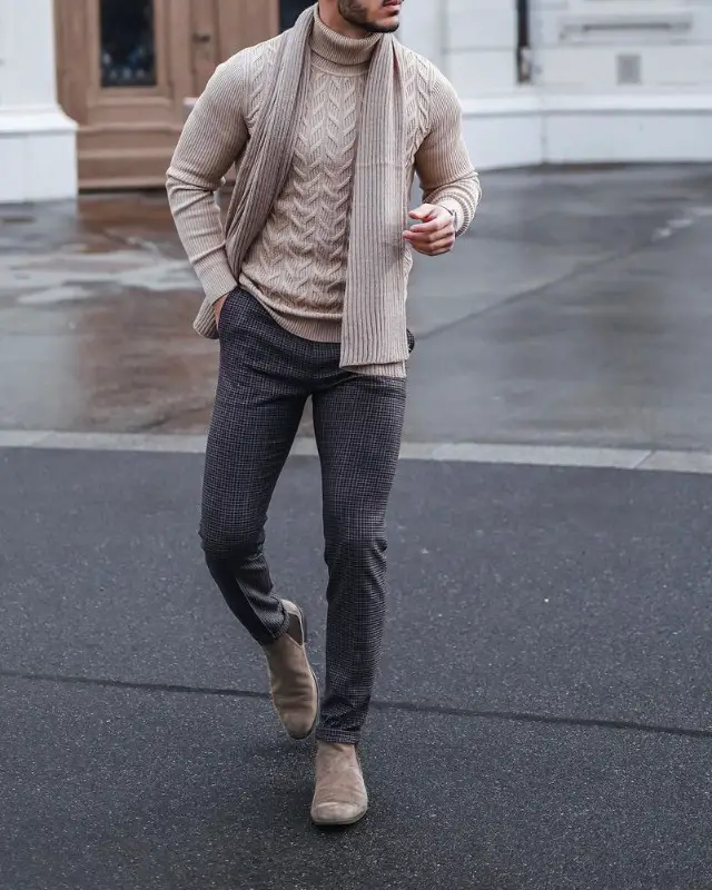 A man wearing Crew-neck sweater, woolen muffler, trousers and Chelsea boots attire.