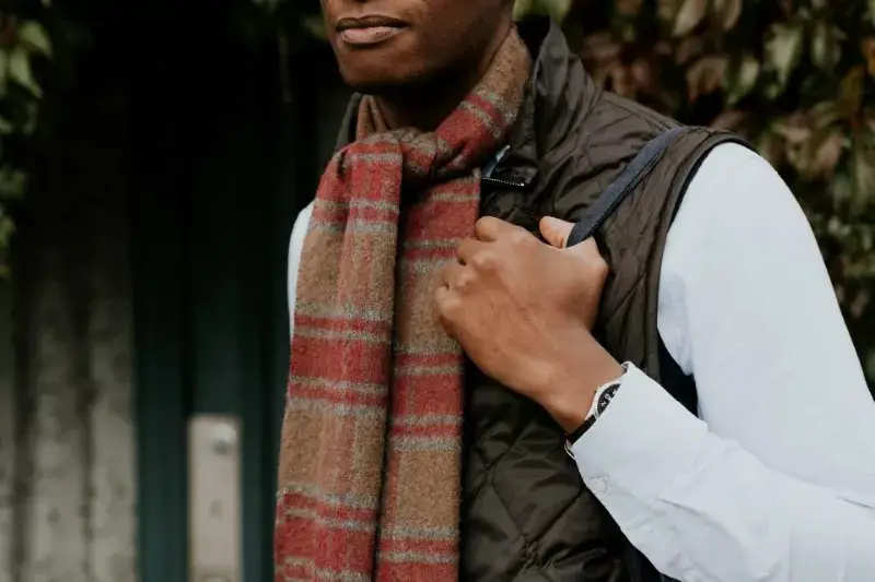 A male carrying blanket scarf with knot style.
