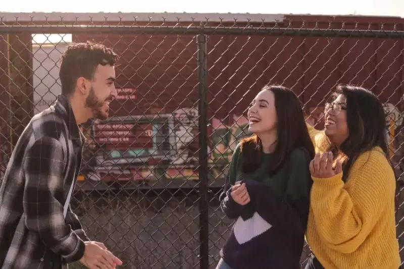 Two girls talking with a guy.