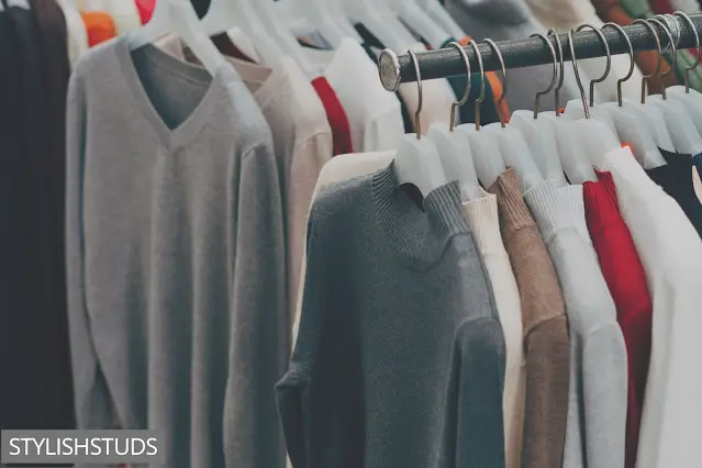 Many Men's sweaters hanging on hangers